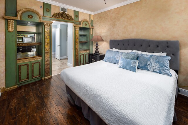 bedroom with ornamental molding and dark hardwood / wood-style floors