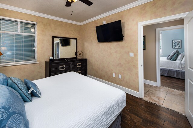 bedroom featuring ceiling fan, crown molding, and dark hardwood / wood-style floors