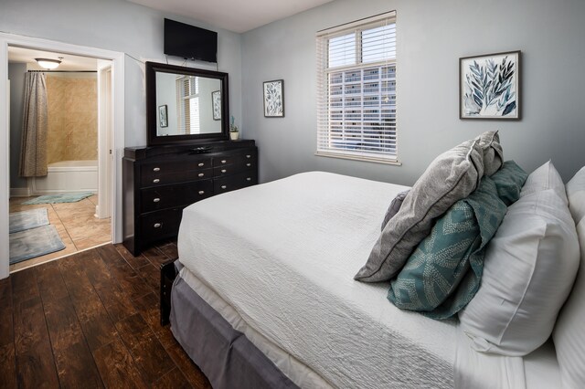 bedroom featuring dark wood-type flooring and connected bathroom