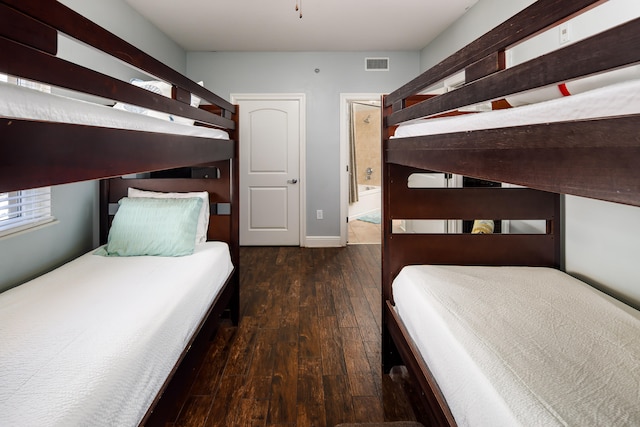 unfurnished bedroom featuring ensuite bath and dark hardwood / wood-style flooring