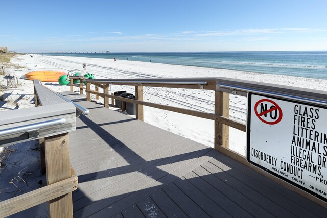 dock area with a water view and a view of the beach