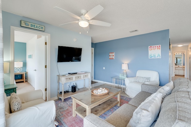 living room featuring a textured ceiling and ceiling fan