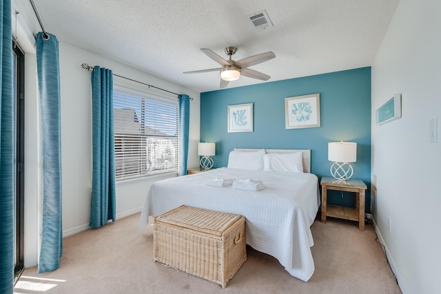 carpeted bedroom featuring a textured ceiling and ceiling fan