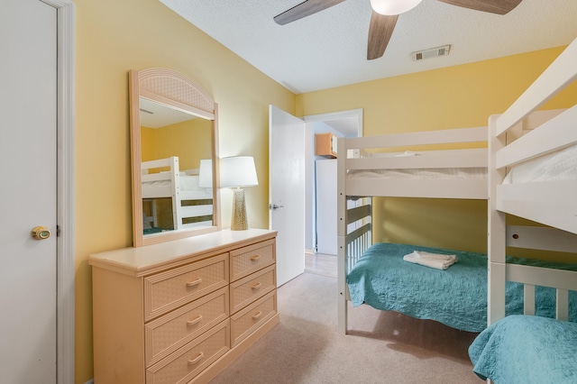 carpeted bedroom with a textured ceiling and ceiling fan