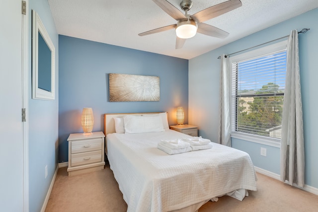 carpeted bedroom featuring a textured ceiling and ceiling fan