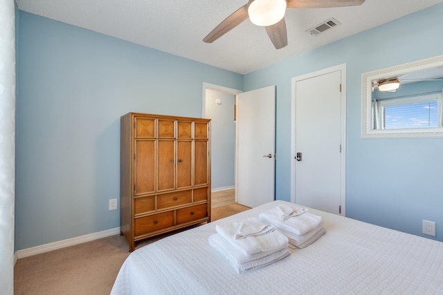 carpeted bedroom featuring ceiling fan and a textured ceiling