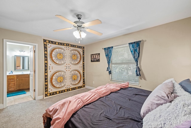 bedroom featuring ensuite bath, light carpet, and ceiling fan