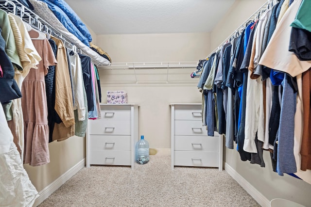 walk in closet featuring light colored carpet