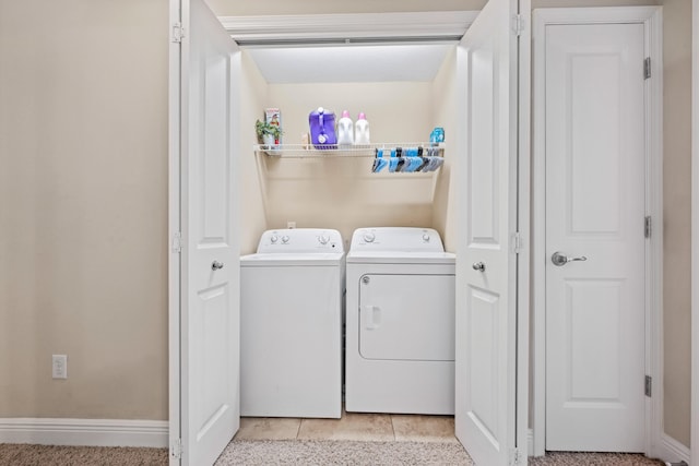 laundry area with washer and dryer and light tile patterned floors