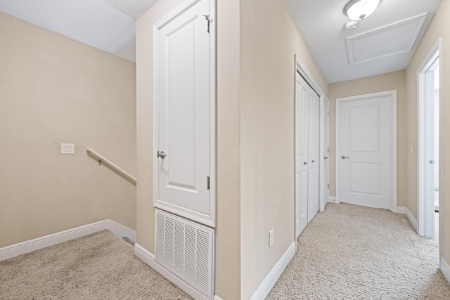 hallway with light colored carpet