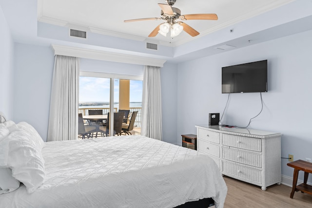 bedroom with access to outside, a raised ceiling, hardwood / wood-style floors, ceiling fan, and crown molding