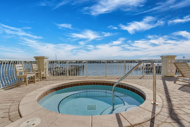 view of pool featuring a community hot tub and a water view