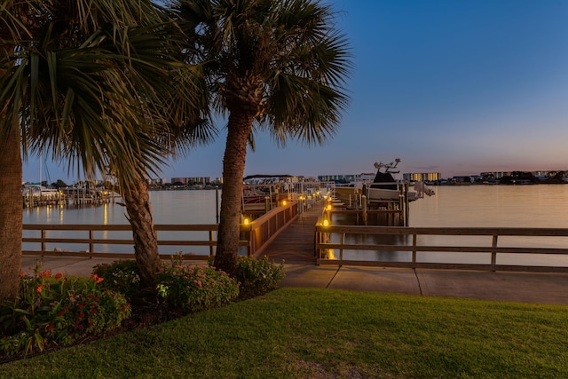 view of dock featuring a water view and a yard