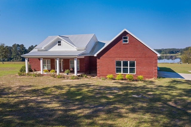 view of front of house with a water view, covered porch, and a front yard