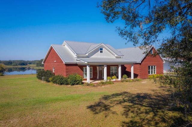 view of front of home with a front lawn and a water view