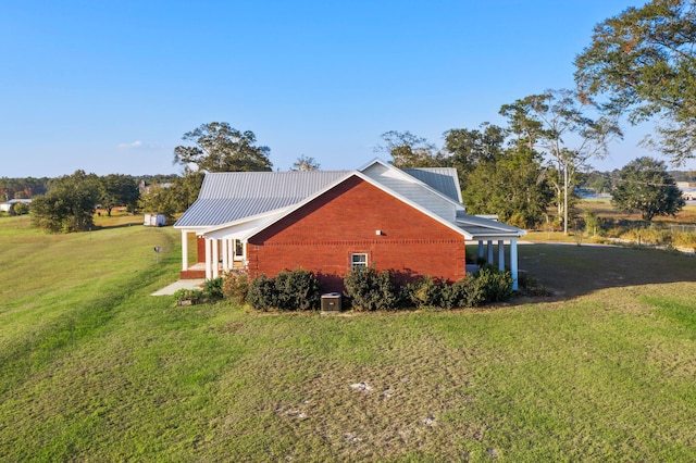 view of side of home with a lawn and central AC unit