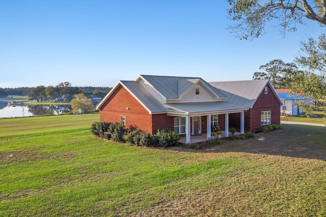 view of front of property featuring a water view and a front lawn