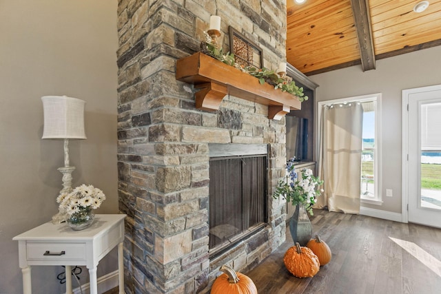 living room with beam ceiling, dark hardwood / wood-style floors, wooden ceiling, and a fireplace