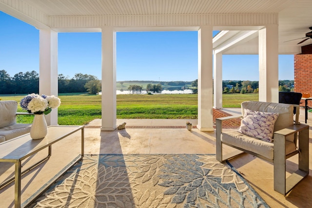 view of patio with a water view and ceiling fan