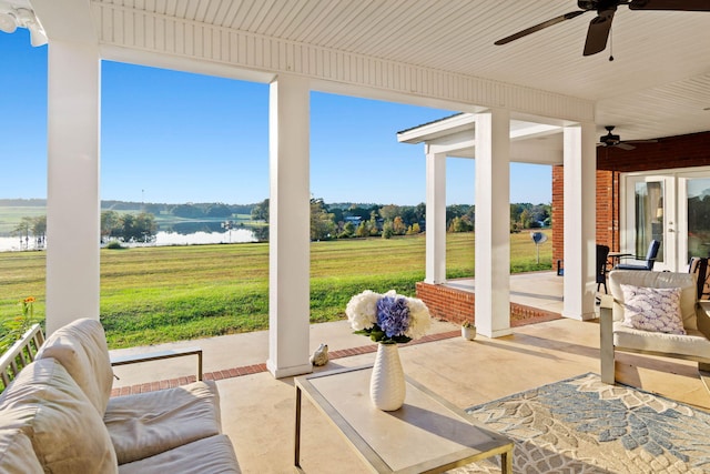 view of patio featuring a water view, ceiling fan, and an outdoor living space