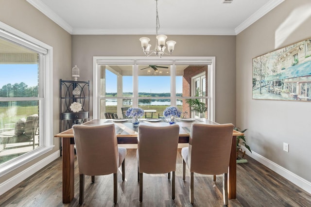 dining space with dark wood-type flooring, crown molding, a water view, and plenty of natural light