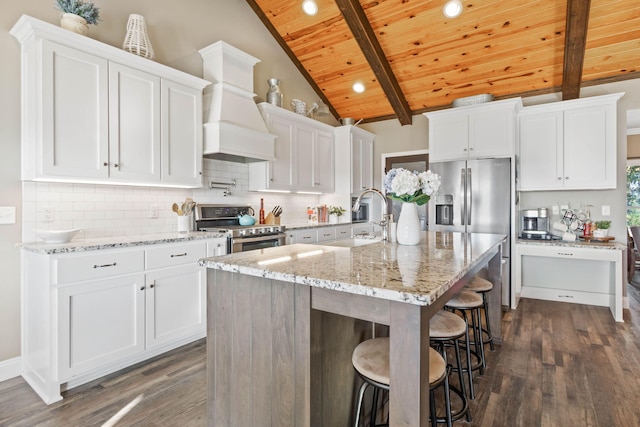 kitchen with dark hardwood / wood-style floors, an island with sink, sink, white cabinetry, and appliances with stainless steel finishes