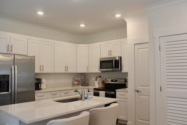 kitchen featuring sink, stainless steel appliances, white cabinets, light stone counters, and a breakfast bar