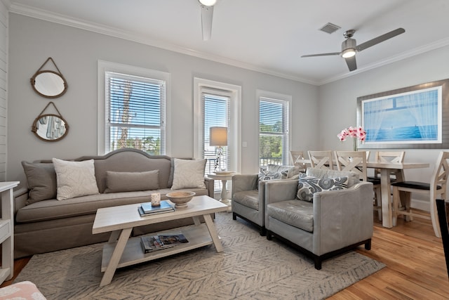 living room featuring ornamental molding, light hardwood / wood-style flooring, and ceiling fan