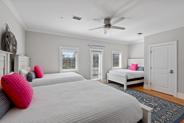 bedroom featuring dark wood-type flooring, ceiling fan, and crown molding