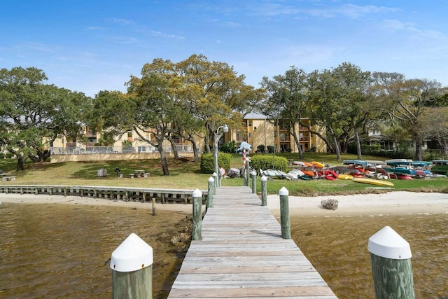 view of dock featuring a water view and a lawn