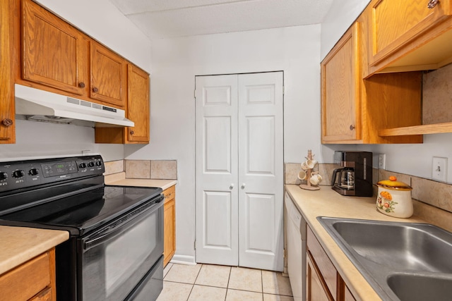 kitchen featuring dishwasher, sink, black electric range oven, and light tile patterned floors