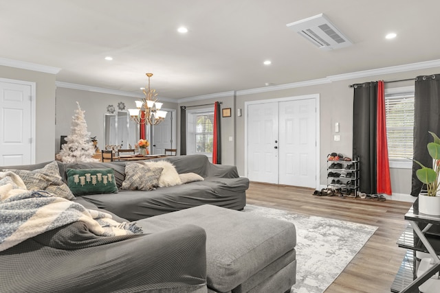 living room with a notable chandelier, light hardwood / wood-style floors, and crown molding