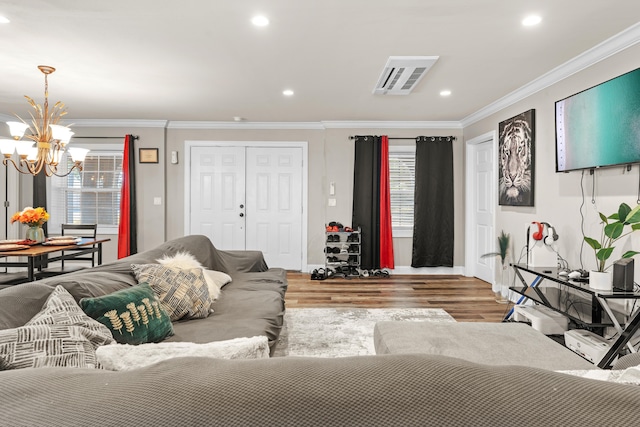 living room with hardwood / wood-style floors, a notable chandelier, and ornamental molding