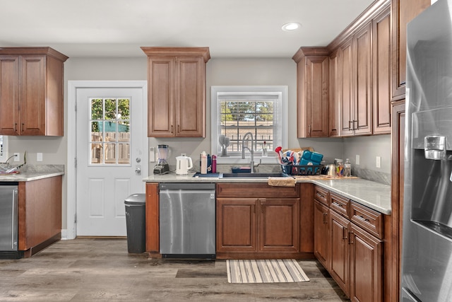 kitchen featuring wood-type flooring, stainless steel appliances, plenty of natural light, and sink