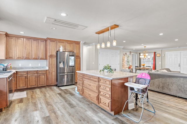 kitchen with hanging light fixtures, light hardwood / wood-style flooring, appliances with stainless steel finishes, a kitchen island, and a kitchen bar