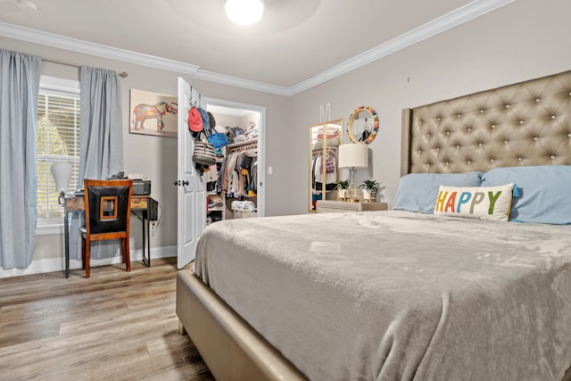 bedroom with a walk in closet, light hardwood / wood-style flooring, a closet, and crown molding