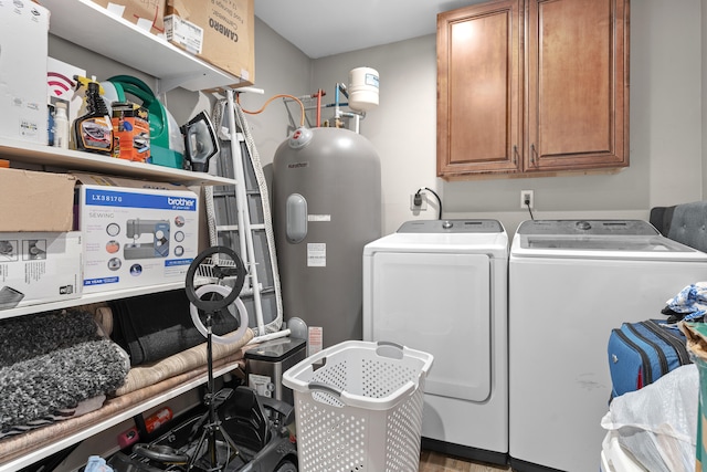 clothes washing area with washing machine and clothes dryer and cabinets