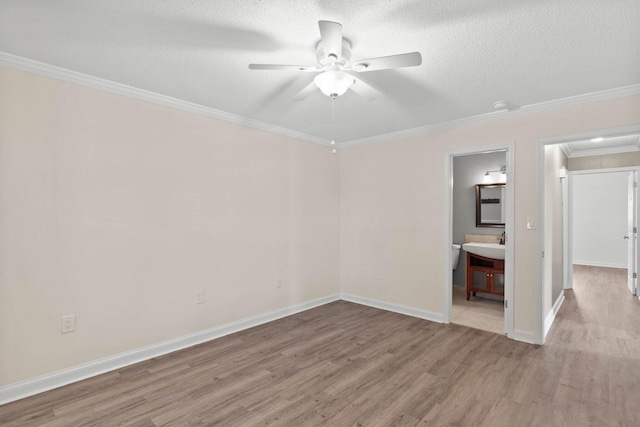 spare room with a textured ceiling, light hardwood / wood-style flooring, ceiling fan, and crown molding