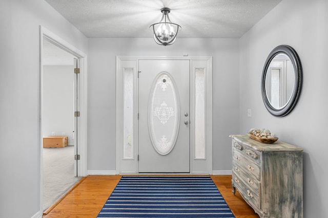 entryway with wood-type flooring and a textured ceiling