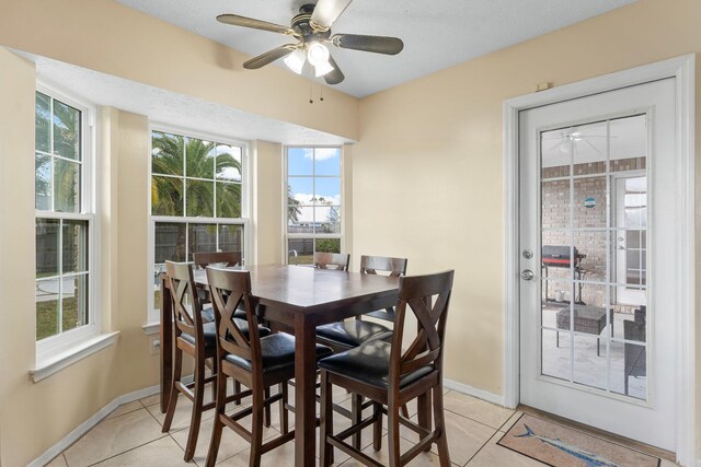 tiled dining space featuring a textured ceiling and ceiling fan