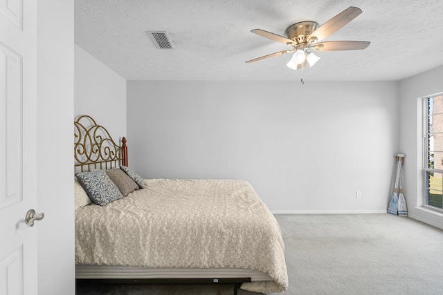 bedroom featuring multiple windows, a textured ceiling, and ceiling fan