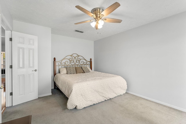 bedroom featuring a textured ceiling, carpet floors, and ceiling fan