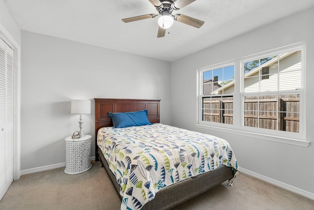 carpeted bedroom featuring a closet and ceiling fan