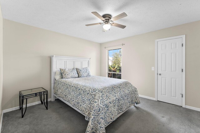 carpeted bedroom featuring ceiling fan and a textured ceiling