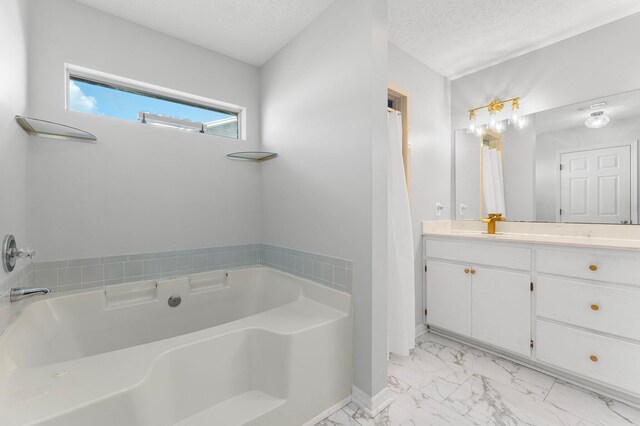 bathroom with vanity, a tub to relax in, and a textured ceiling