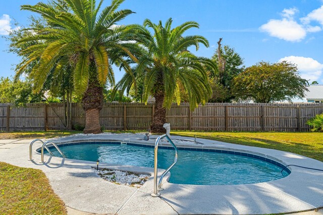 view of swimming pool featuring a yard