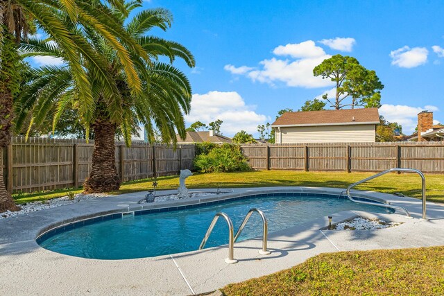 view of swimming pool with a yard