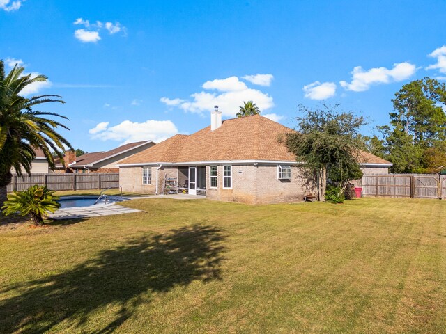 back of house with a fenced in pool, a yard, and a patio