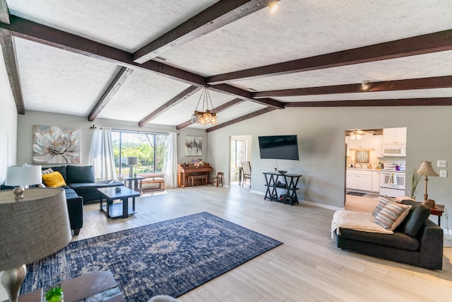 living room with a chandelier, lofted ceiling with beams, a textured ceiling, and light wood-type flooring