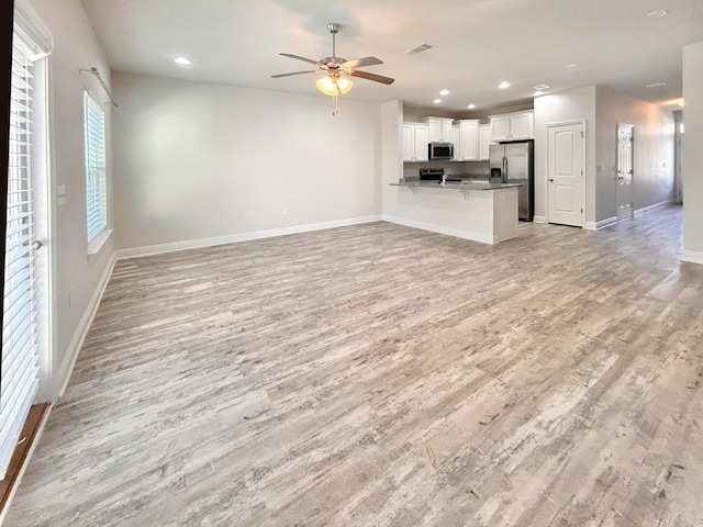 unfurnished living room featuring light wood-type flooring and ceiling fan